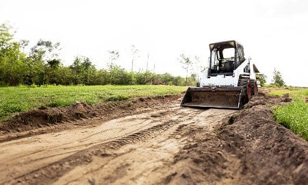 A skid steer working in a field